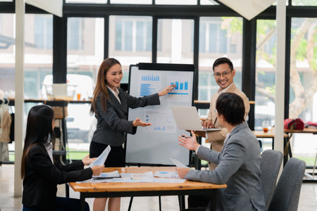 Group of Asian business people discussing charts and graphs showing the results of successful business investment and growth showing the results of successful teamwork.の写真素材