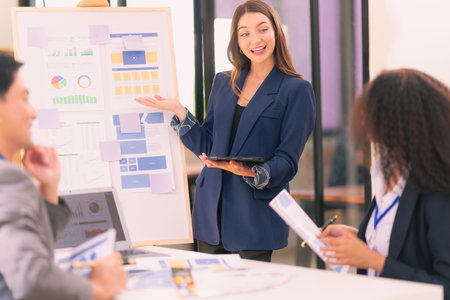 Group of business people discussing charts and graphs showing results of teamwork, analyzing financial data at desk in modern office about business strategy.の写真素材