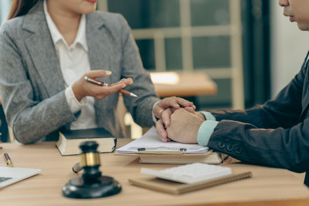 Professional business people working and discussing in law office. Judge's gavel with scales of justice. Consultation and discussion meeting in law office.の写真素材
