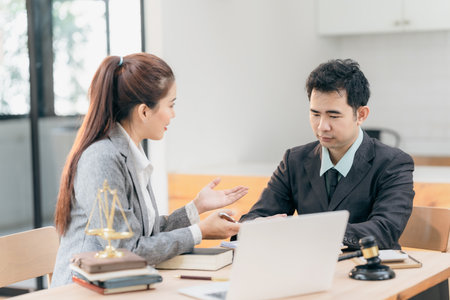 Professional business people working and discussing in law office. Judge's gavel with scales of...
