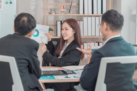 Business team discussing charts and graphs about investment and business growth. Business colleagues analyzing financial data at desk in office.の写真素材