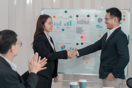 Business team shows unity by shaking hands and represents the concept of friendship, teamwork and...
