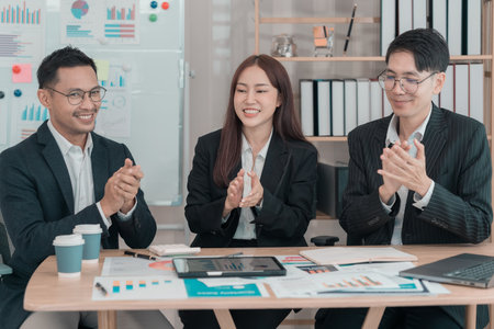 Group of creative young Asian business people expressing joyful excitement with success, teamwork, celebration of success.の写真素材