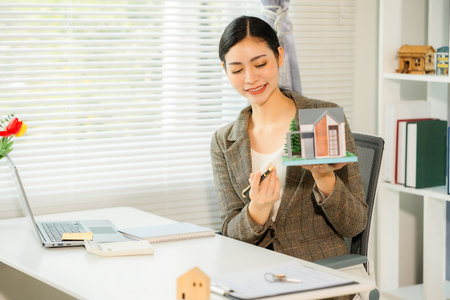 Asian female real estate agent explaining business contracts, lease agreements, loans and banks for new home purchase, vertical photoの写真素材