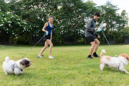 Asian couple walking with their dog in the park in the morning. Friendly pets, a healthy morning...