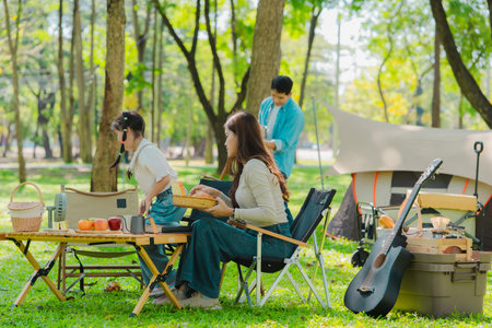 Asian family traveling and camping in the forest feeling happy during family time, adventure and travel concept family activities and outdoor activitiesの写真素材