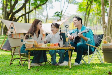 Asian family traveling and camping in the forest feeling happy during family time, adventure and travel concept family activities and outdoor activitiesの写真素材