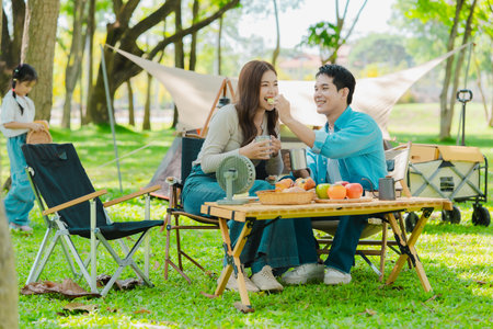 Asian family traveling and camping in the forest feeling happy during family time, adventure and travel concept family activities and outdoor activitiesの写真素材