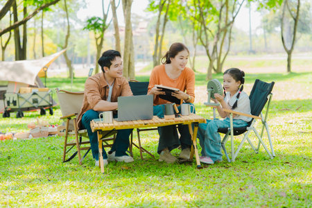 Asian family camping in the forest feeling happy during family time, adventure and travel concept family activities and outdoor activitiesの写真素材