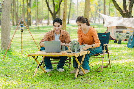 Asian family traveling and camping in the forest feeling happy during family time, adventure and travel concept family activities and outdoor activitiesの写真素材