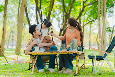 Asian family traveling and camping in the forest feeling happy during family time, adventure and travel concept family activities and outdoor activitiesの写真素材