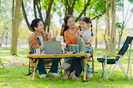 Asian family camping in the forest feeling happy during family time, adventure and travel concept family activities and outdoor activitiesの写真素材