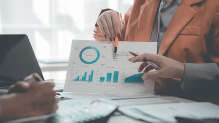 Business people discussing, there are financial charts and graphs on the table, discussing about...