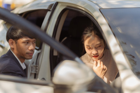 Male insurance agent inspects damaged car after accident and submits claim documents from insurance...