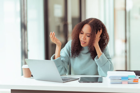 Young woman using digital tablet and laptop working in office