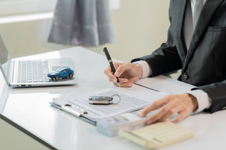 An online car insurance agent sits at a desk explaining the contract for sale.の写真素材