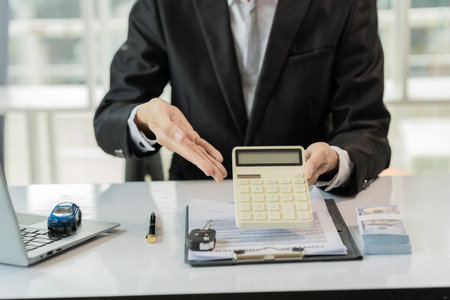 An online car insurance agent sits at a desk explaining the contract for sale.の写真素材