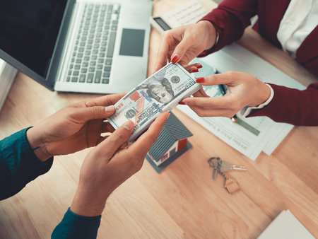 Close-up of real estate agent presenting and advising clients on signing insurance contract forms and mortgage loan proposals in office.の写真素材