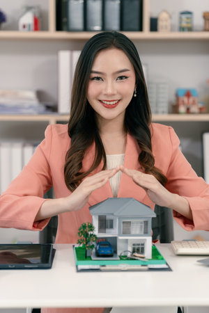 Asian female home insurance agent with a small house, business concept of insurance, protection and real estate, property insuranceの写真素材
