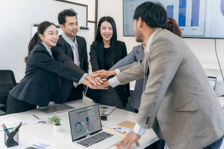 Group of Asian business people working together as a team to plan company strategy in brainstorming...