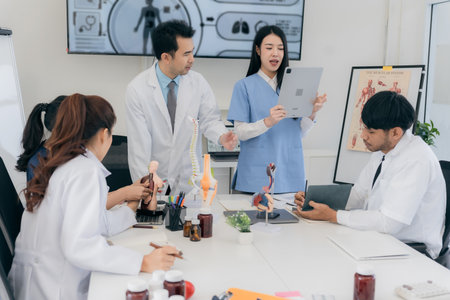 A group of young Asian physicians are talking with colleagues in a medical conference room, discussing and reviewing rare disease cases to improve practice guidelines. Doctorsの写真素材