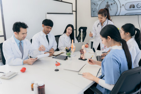 A group of young Asian physicians are talking with colleagues in a medical conference room, discussing and reviewing rare disease cases to improve practice guidelines. Doctorsの写真素材