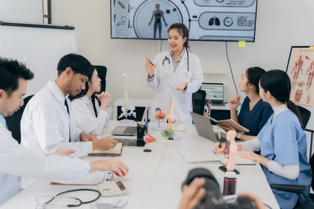 A group of young Asian physicians are talking with colleagues in a medical conference room, discussing and reviewing rare disease cases to improve practice guidelines. Doctorsの写真素材
