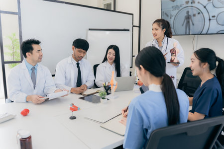 A group of young Asian physicians are talking with colleagues in a medical conference room, discussing and reviewing rare disease cases to improve practice guidelines. Doctorsの写真素材