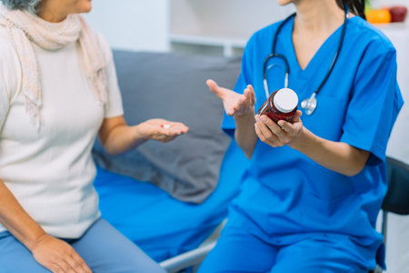 Doctor is examining elderly female patient in ward while doctor is checking her condition in...