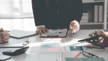 Group of business people discussing charts and graphs showing success of office meeting to analyze financial reports, planning strategies and collaboration efficiency.の写真素材