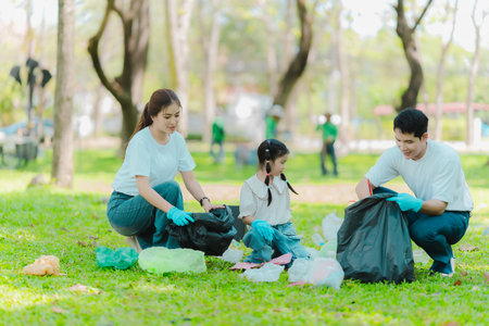 Volunteers collect trash in the park, clean up the area, volunteer concept, charity, people and ecology, Asian family collecting plastic waste, World Cleanup Dayの写真素材