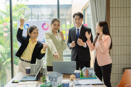 Celebrating success, hands raised in appreciation for real estate development, teamwork, men and women cheering, engineering and company progress.の写真素材