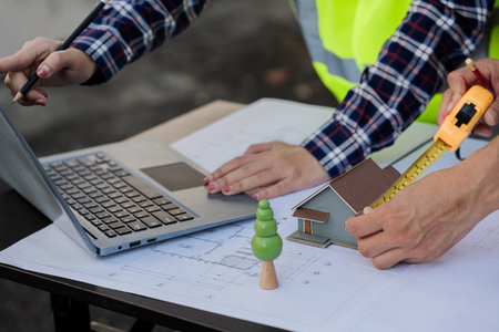 Architects, laptops and team members are meeting to discuss construction strategies or project planning or blueprints for construction.の写真素材