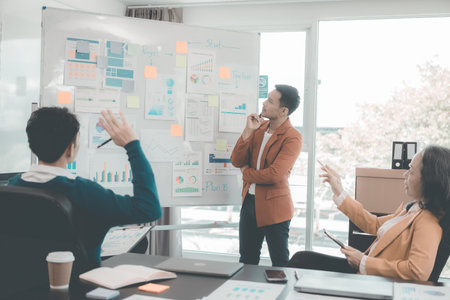 Group of business people discussing charts and graphs showing results of teamwork of colleagues working together at desks in office and discussing documents.の写真素材
