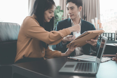 A serious lawyer discussing legal documents will examine important documents during a serious consultation, with the hammer and scales that are the hallmarks of justice.の写真素材