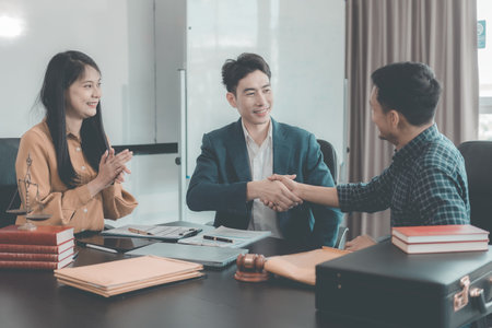 A serious lawyer discussing legal documents will examine important documents during a serious consultation, with the hammer and scales that are the hallmarks of justice.の写真素材