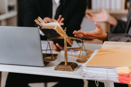 Lawyer, man giving advice to client at table with scales and gavel. Lawyer handing document and pen to client. Legal services concept. Close up.の写真素材