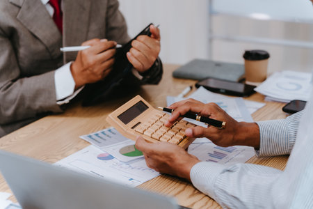 Business people discuss charts and graphs that show the results of teamwork, effective data analysis, and the success of the finance department's planning.の写真素材