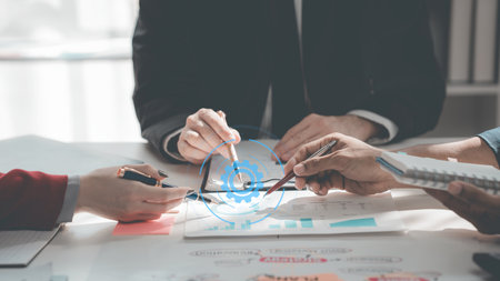 Business people discussing charts and graphs showing results of teamwork in a meeting to analyze financial reports, planning strategies, success.の写真素材