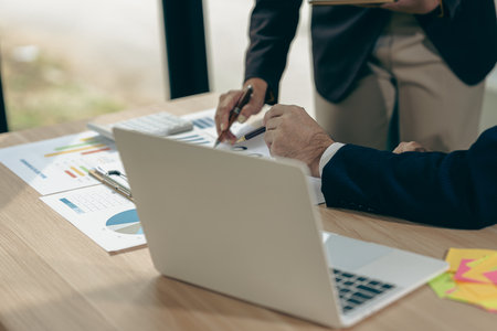 Business people discussing charts and graphs showing results of teamwork in a meeting to analyze financial reports, planning strategies, success.の写真素材