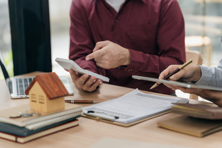 Real estate agents hand over the keys to clients after signing the contract and provide advice to clients on the decision to sign the insurance agreement form.の写真素材