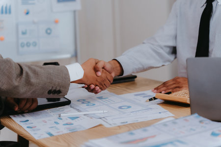 Businessman shaking hands with colleague, close cooperation with signature on desk, starting cooperation, partnership and success in teamwork.の写真素材