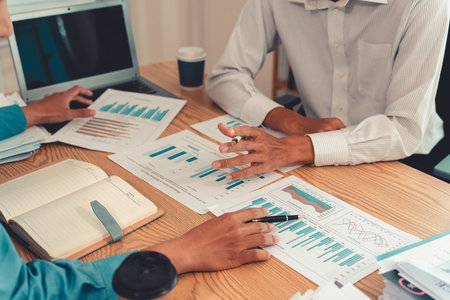 Business people discussing charts and graphs showing the results of successful teamwork with...