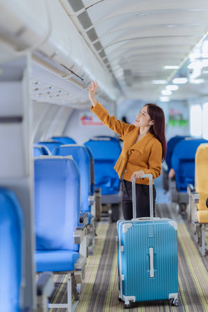 Businesswoman walking with luggage on airplane. Concept of business travel, transportation, aviation and luxury tourism. Commercial airplane.の写真素材