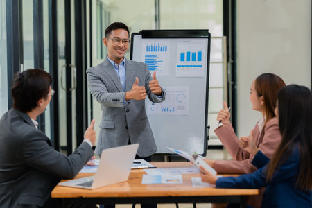 Group of business people discussing business plan in office conference room. Project planning, creative brainstorming, discussing ideas, using documents, digital devices.の写真素材