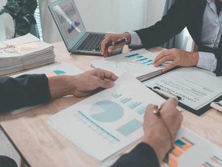 Business and investment concepts: Business people are discussing charts and graphs that show the results of successful teamwork (close-up view).の写真素材