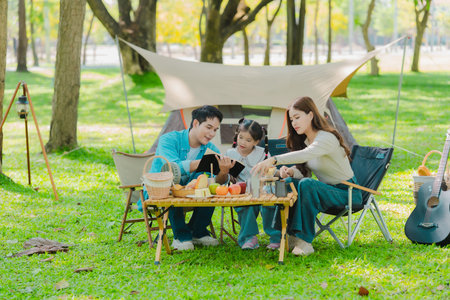 The concept depicts the lifestyle of Asian families enjoying camping together in a park, a concept of relaxation.の写真素材