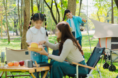 The concept depicts the lifestyle of Asian families enjoying camping together in a park, a concept of relaxation.の写真素材