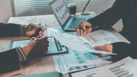 Business professionals are discussing charts and graphs that illustrate the results of successful...