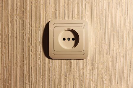 Beige wall plug with a sharp shadeの写真素材
